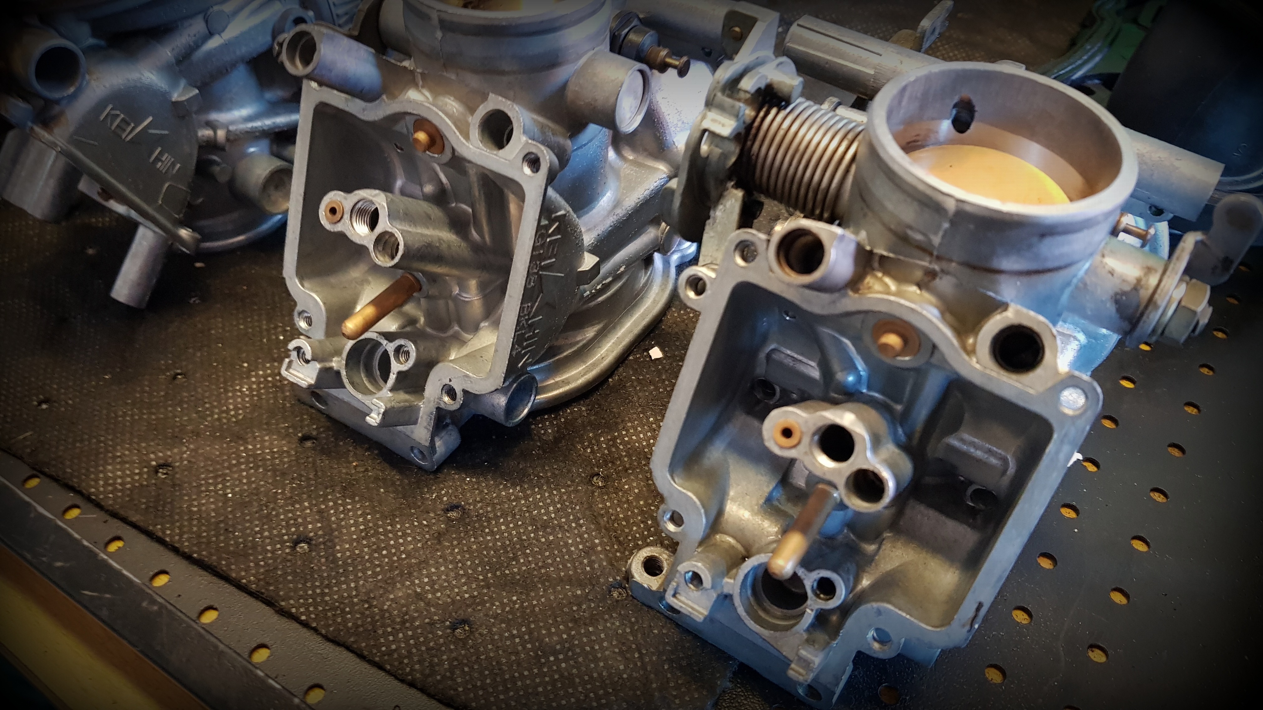 Rozebraný motocyklový karburátor před repasí